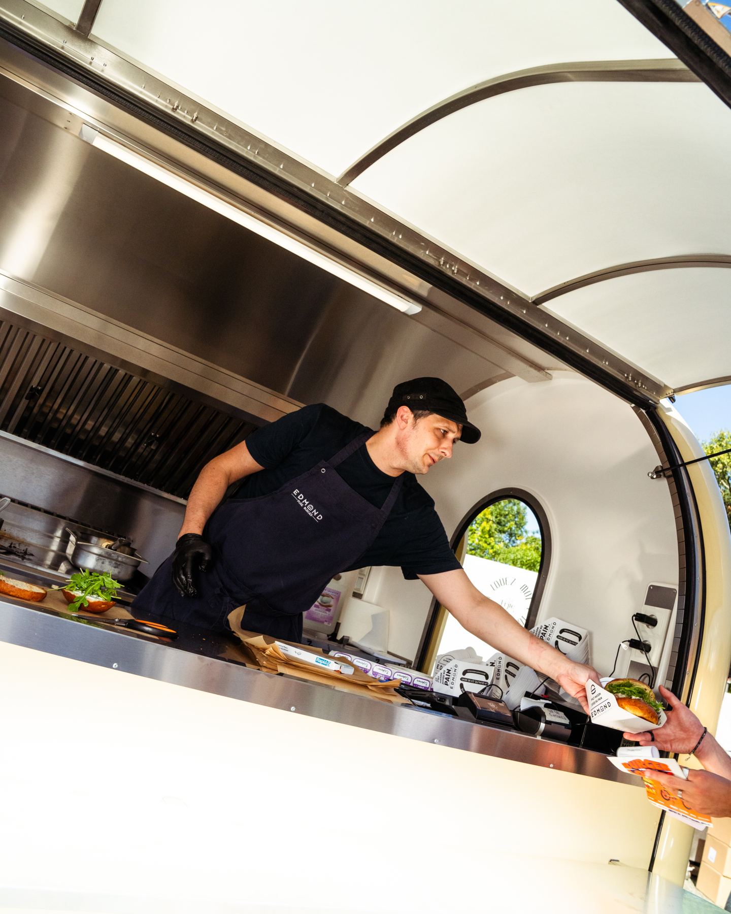 Een kok bedient een klant vanuit zijn foodtrailer
