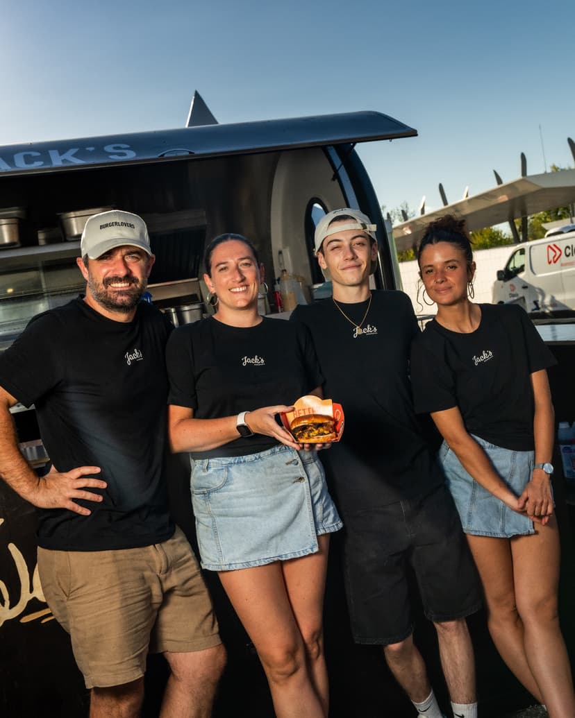 Het team van Jack’s Burger voor zijn foodtrailer, met een burger in de hand